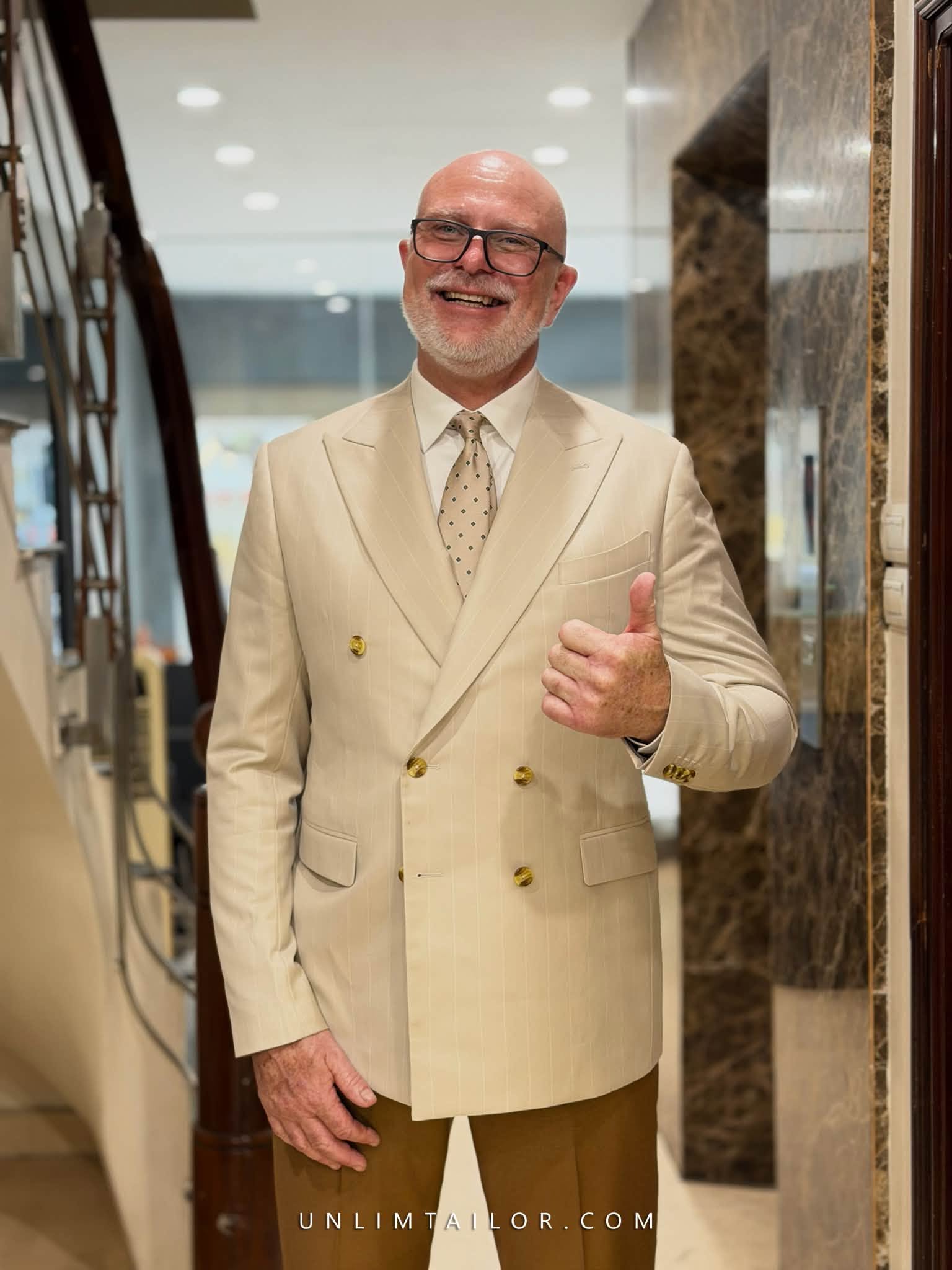 A dark beige, pinstriped suit featuring custom made buttons, tailored by Unlim Tailor in Hanoi