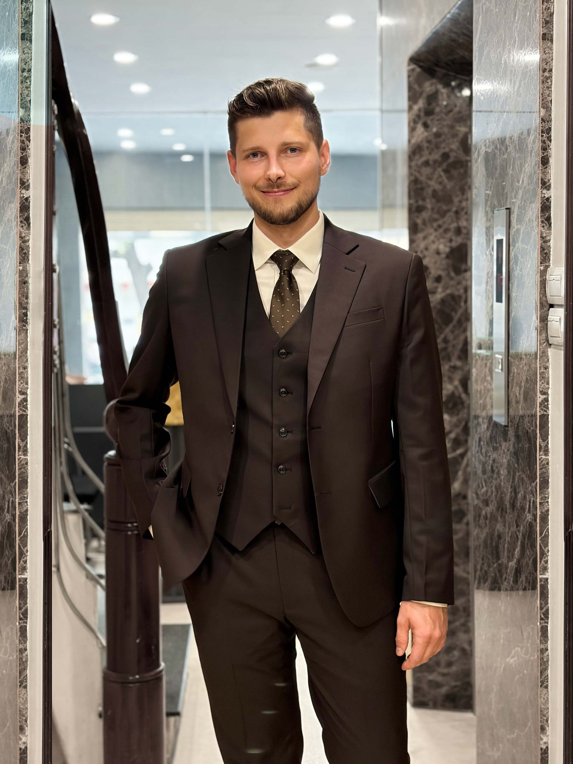 The black suit - tailored by Unlim Tailor, stands out with its youthful collar design.