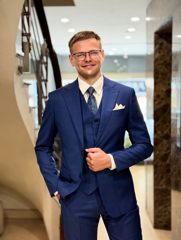 A navy blue three-piece suit, complete with a pocket square, designed by Unlim Tailor.