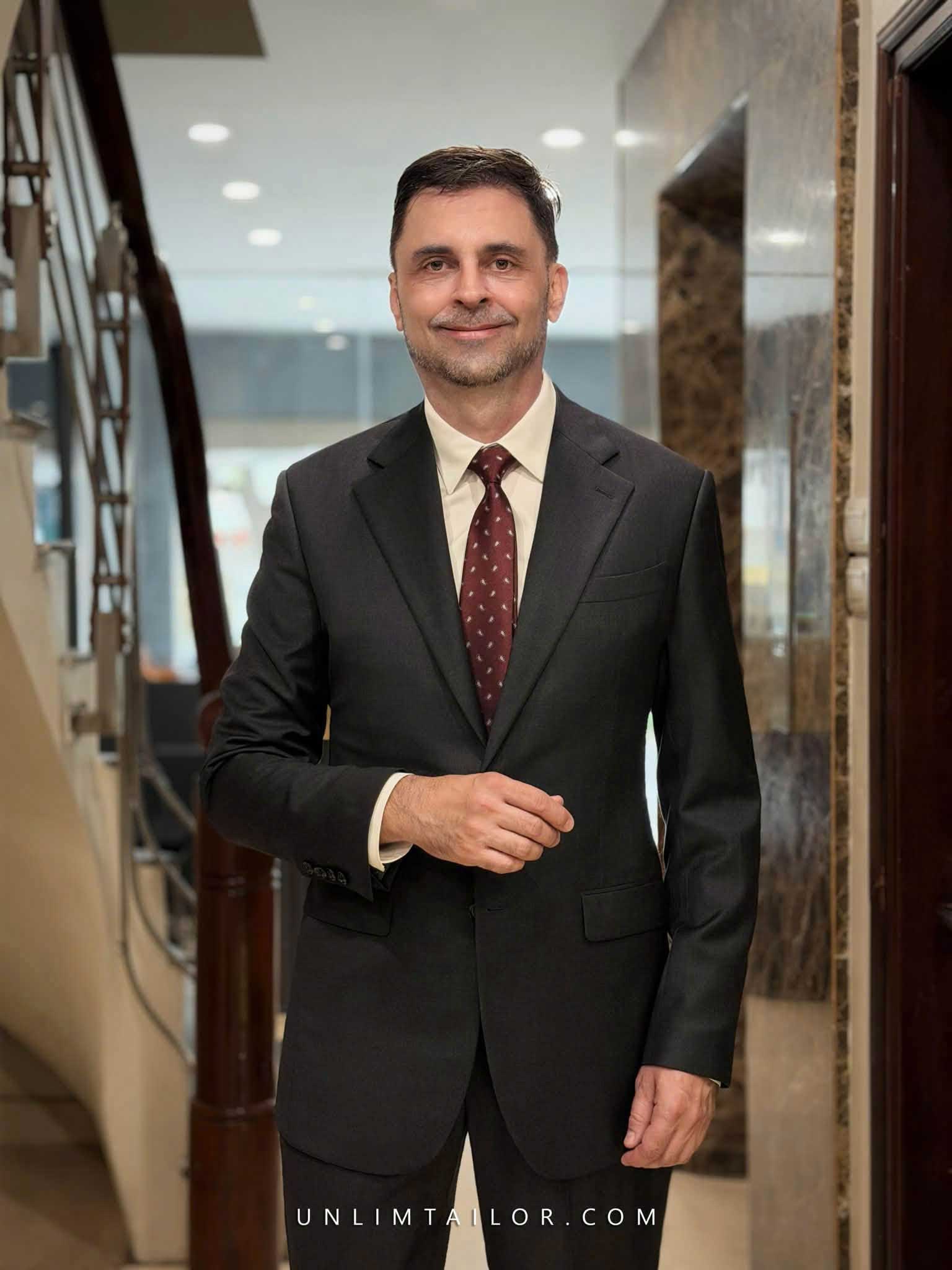 A charcoal grey- two-button tailored suit by Unlim Tailor.